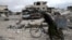 A man walks with his bicycle at a damaged site in the besieged town of Douma, eastern Ghouta, in Damascus, Syria March 30, 2018.