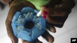 A woman infected with HIV prepares her medicines in a shelter house in Jayapura of the Indonesia Papua province.