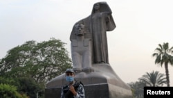 A police officer wearing a protective face mask stands guard next to a statue called "Egypt's Renaissance" during Ramadan as Egypt ramps up efforts to slow the spread of the COVID-19, in Giza, May 16, 2020.