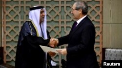 حسن الشِهی، سفیر جدید امارات (چپ) استوارنامه خود را به فیصل المقداد وزیر امور خارجه سوریه تسلیم کرد.