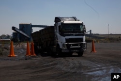 FILE — A truck, is loaded with coal near Emalahleni (formerly Witbank) east of Johannesburg, on Nov. 17, 2022. South African authorities say they have worked to break up a huge coal-smuggling syndicate that contributed to the breakdown of some of its state-owned power stations.