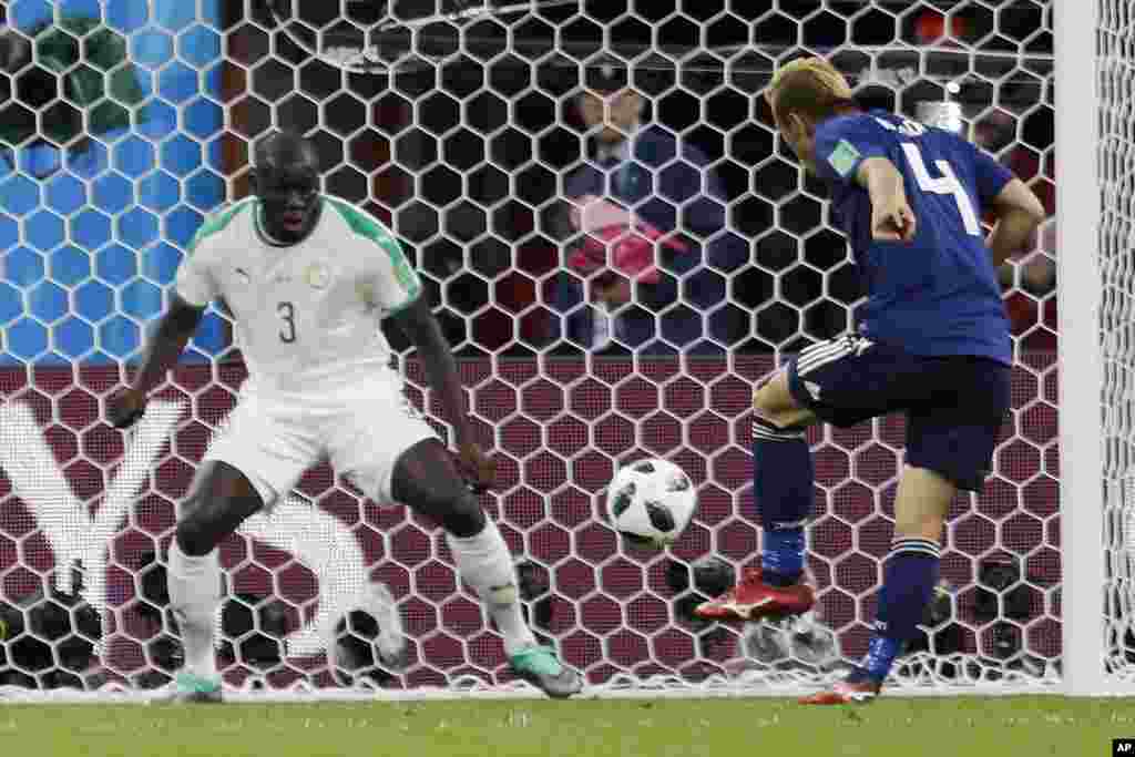 Mchezaji wa Japan Keisuke Honda, kulia, akifunga goli la pili kwa timu yake baada ya kumpita mchezaji wa Senegal Kalidou Koulibaly wakati wa mechi ya kundi H kati ya Japan and Senegal katika uwanja wa Yekaterinburg, mjini Yekaterinburg , Russia, Jumapili, Juni 24, 2018.&nbsp;