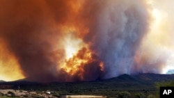 In this frame from video, flames and smoke can be seen rising from a fire near Mayer, Arizona, June 27, 2017. 