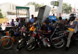 Moto-taxi drivers wait their turn to fill their tanks at a gas station, in Port-au-Prince, July 13, 2021, almost a week after President Jovenel Moise was assassinated in his home.