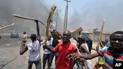 Nan masu zanga-zanga ne dauke da sanduna da barandamai ke zanga-zanga a birnin Kano Arewacin Nigeria, inda ake tafka rikici tsakanin masu zanga-zanga da jami'an soja ran litinin 18 ga watan Afrilun shekarar 2011,bayan fara bayyana sakamakon zaben dake n