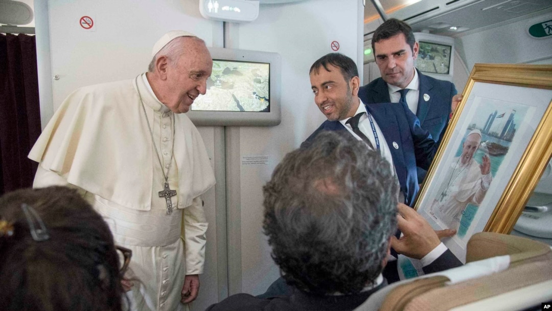 Papa Franja prima poklon od novinara tokom leta iz Abu Dabija ka Rimu, 5. februara 2019.
