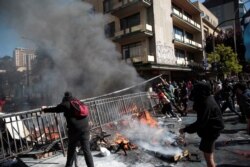 Demonstrators move a fence to use as a barricade during a protest in Concepcion, Chile, Oct. 23, 2019.