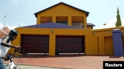 A boy cycles in front of a house in the upmarket Diepkloof extention in Soweto, South Africa, February 2006 file photo. 