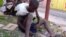 FILE - A homeless child repairs a shoe along a street in the in capital Kinshasa, in the Democratic Republic of Congo, June 2013.