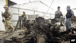 Afghan policemen (R) and foreign soldiers (L) with the NATO- led International Security Assistance Force (ISAF) inspect the scene of a suicide attack in Herat, west of Kabul, Nov. 3, 2011