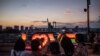 La gente toma fotografías de una réplica de la Estatua de la Libertad en el paseo marítimo de Odaiba en Tokio el 22 de julio de 2021, en vísperas del inicio de los Juegos Olímpicos de Tokio 2020. (Foto de Philip FONG / AFP)