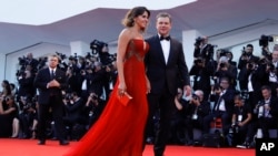 Actor Matt Damon and his wife, Luciana Barroso, walk the red carpet for the screening of the movie "Downsizing," presented at the 74th edition of the Venice Film Festival, at Venice Lido, Italy, Aug. 30, 2017. 