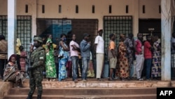A Rwandan soldier looks on as as voters queue to vote at the Barthélemy Boganda high school polling station in the 1st district in Bangui, Central African Republic (CAR), on Dec. 27, 2020. 