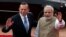 Australia's Prime Minister Tony Abbott and his Indian counterpart Narendra Modi (R) wave towards the media during Abbott's ceremonial reception at the forecourt of India's presidential palace Rashtrapati Bhavan in New Delhi, Sept. 5, 2014. 