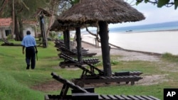 FILE - A security-guard walks past empty sun loungers facing the Indian Ocean at a holiday resort in the town of Diani, south of Mombasa, on the coast of Kenya Thursday, May 22, 2014.