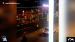 In this screen grab of a video shared on social media and vetted by the Associated Press, an Iranian policeman apparently stands in the street in Susangerd after firing in the air toward protesters who run away from him on July 18, 2021. 