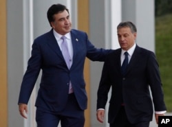 FILE - Then-Georgian President Mikhail Saakashvili, left, speaks to Hungarian Prime Minister Viktor Orban during a welcome ceremony in Tbilisi, Georgia, on Sept. 26, 2012.