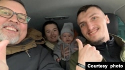 Myroslav Pylypchuk, right, is seen with American volunteer Ron Jackson, left, with Myroslav's wife and son in the background. (Courtesy - Myroslav Pylypchuk)