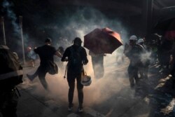 A demonstrator kicks back an exploded tear gas shell in Hong Kong, Oct. 1, 2019, during an escalation of protests in the semi-autonomous Chinese territory.