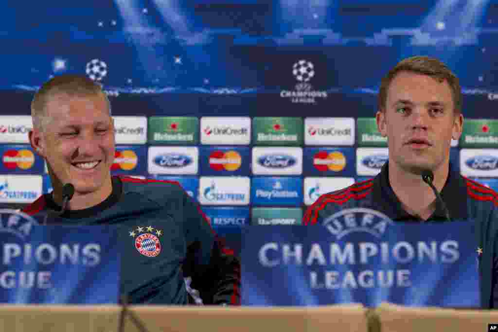Bayern Munich's Bastian Schweinsteiger, left, and goalkeeper Manuel Neuer smile during a press conference in Manchester, England, Monday, March 31, 2014. Bayern Munich will play Manchester United in a Champions League quarter final first leg soccer match
