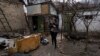 Una mujer camina con un gato entre los cadáveres de su esposo y un hermano en Bucha, Ucrania, el 4 de abril de 2022.