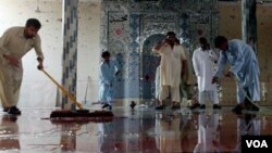 Jamaah membersihkan lantai masjid setelah serangan bom bunuh diri di Darra Adam Khel, selatan Peshawar, Pakistan.