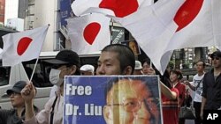 A Japanese protester holding a placard with a message reading, "Free (Nobel Peace Prize winner) Dr. Liu Xiaobo," marches down streets in central Tokyo as an estimated 2,500 protesters take to the streets in a protest against China, 16 Oct 2010.