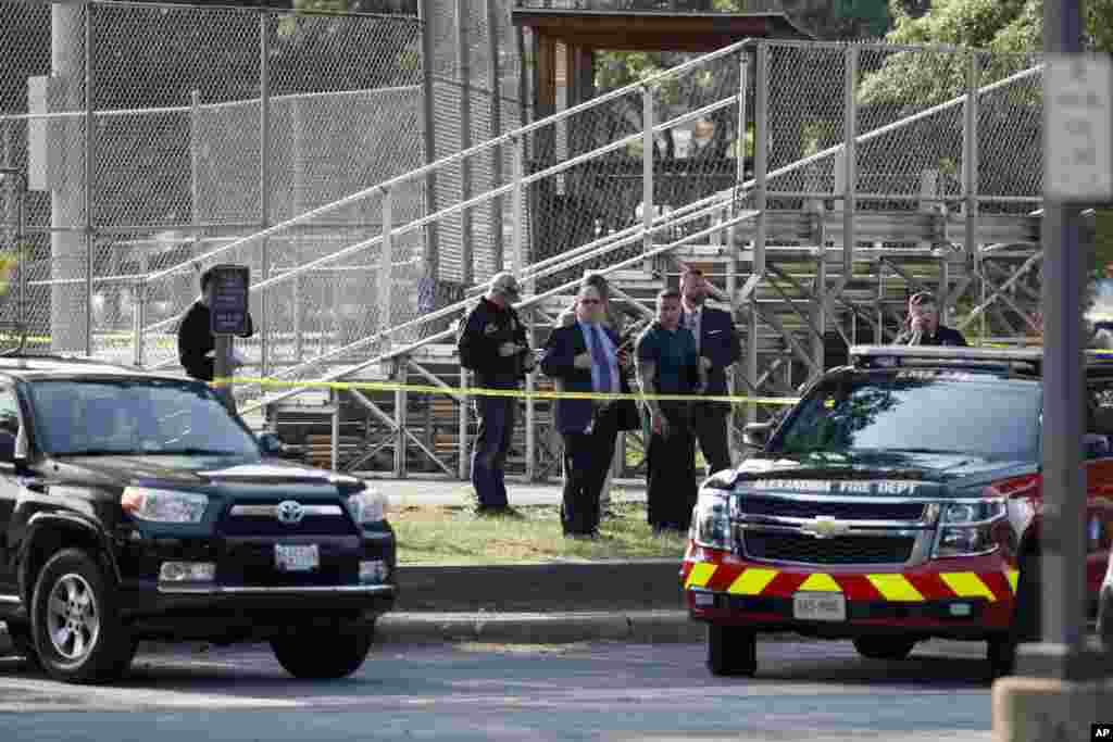 Law enforcement officers investigate the scene of a shooting near a baseball field in Alexandria, June 14, 2017.