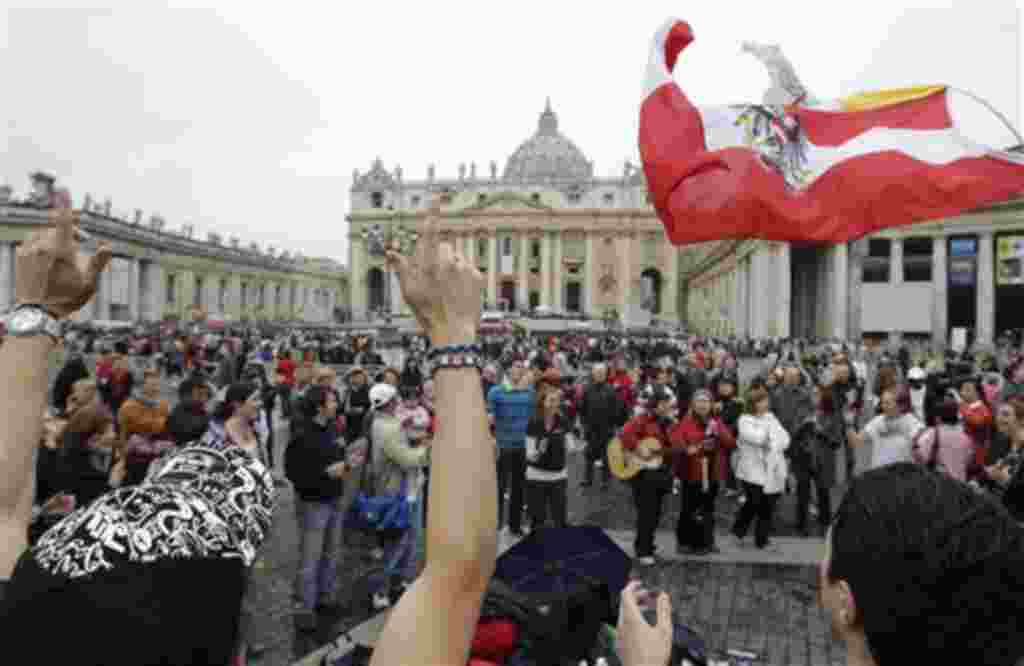 Peregrinos procedentes de Polonia ondear una bandera del país y cantan reunidos en la Plaza de San Pedro, en el Vaticano, el 30 de abril de 2011, un día antes de la beatificación del Papa Juan Pablo II.