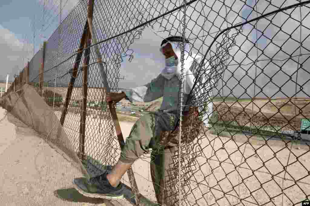 A Palestinian man enters illegally from a breach in a barrier fence into Israeli territory from the village of al-Dahriya, south the occupied West Bank town of Hebron.