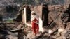 A Pakistani Kashmiri woman stands amid debris of her home that reportedly was destroyed by cross border shelling from Indian troops, in Neelum Valley, at the Line of Control in Pakistani Kashmir, Dec. 23, 2019. 