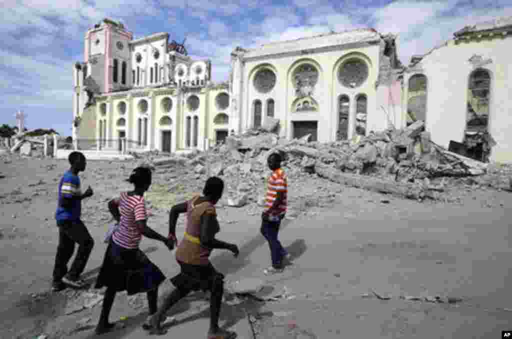 People walk by the Cathedral which collapsed during an earthquake in Port-au-Prince, Thursday, Jan. 14, 2010. A 7.0-magnitude earthquake struck Haiti Tuesday. (AP Photo/Gregory Bull)