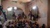FILE - In this July 18, 2017 file photo, Suspected Islamic State members sit inside a small room in a prison south of Mosul, Iraq. 