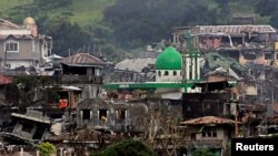 Damaged buildings and houses are seen as government forces continue their assault against insurgents from the Maute group, who have taken over large parts of Marawi city, Philippines, June 22, 2017. 