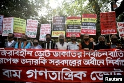 FILE - Activists of the leftist alliance cover their mouths with black cloths as they join in a rally to demand a new election under caretaker government, in Dhaka, Bangladesh, Jan. 3, 2019.