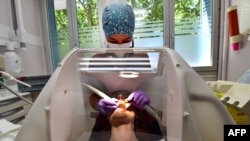 Un paciente recibe atención de un dentista protegido por un escudo de plexiglás y silicio contra el nuevo coronavirus (COVID-19), el 7 de julio de 2020 en Toulouse, sur de Francia.