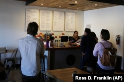 In this Friday, October 18, 2019 photo, patrons line up to place their orders for Mexican vegan food at the Earth Plant Based Cuisine restaurant in Phoenix.