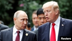 U.S. President Donald Trump, right, and Russia's President Vladimir Putin talk during the family photo session at the APEC Summit in Danang, Vietnam Nov. 11, 2017