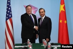 U.S. Secretary of State Mike Pompeo and China's Foreign Minister Wang Yi shake hands before their bilateral meeting at the 51st Association of Southeast Asian Nations (ASEAN) in Singapore, Aug. 3, 2018.