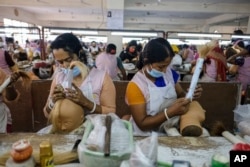Workers set hair on mannequins at a factory inside an export processing zone in Mongla, Bangladesh, March 3, 2022. (AP Photo/Mahmud Hossain Opu)