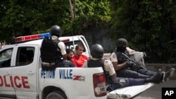 Police take two detainees to the police station of Petion Ville, Port-au-Prince, Haiti, July 8, 2021. According to Police Chief Leon Charles, the two detainees are suspects in the assassination of Haitian President Jovenel Moïse. 