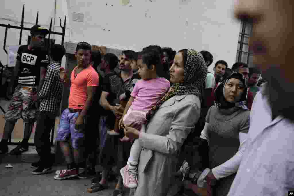 Immigrants wait outside a police station to receive temporary traveling papers at Kos island, Greece, May 27, 2015. 