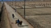 FILE - North Korean farmers pass along a road past farm fields at a collective farm near the town of Sariwon, in North Hwanghae province, North Korea.