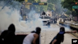 ARCHIVO - Manifestantes chocan con la policía durante manifestaciones contra los resultados oficiales de las elecciones que declaran la reelección del presidente Nicolás Maduro, el día después de la votación en Caracas, Venezuela, el 29 de julio de 2024. 