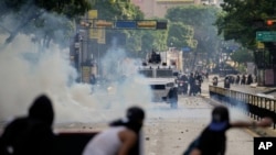 ARCHIVO - Manifestantes se enfrentan con la policía durante protestas contra los resultados electorales oficiales que declaran la reelección del presidente Nicolás Maduro, en Caracas, Venezuela, el 29 de julio de 2024.