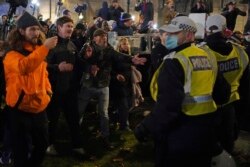 Anti -COVID-19 vaccination protesters react with police during a protest on Whitehall, in London, Dec. 18, 2021.