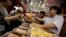 FILE - A vendor, right, sells mooncakes to a customer, left, at a shop in Shanghai, China. 
