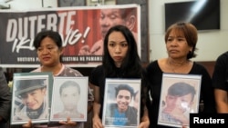 Kerabat dari para korban yang tewas dalam perang melawan narkoba yang digalakkan mantan Presiden Rodrigo Duterte membawa foto korban dalam konferensi pers di Quezon Citi, Manila, Filipina, pada 12 Maret 2025. (Foto: Reuters/Lisa Marie David)