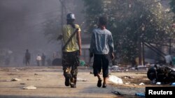 Orang-orang membawa senjata dalam kerusuhan sektarian antara warga Budha dan Muslim di kota Meikhtila, Burma (22/3).