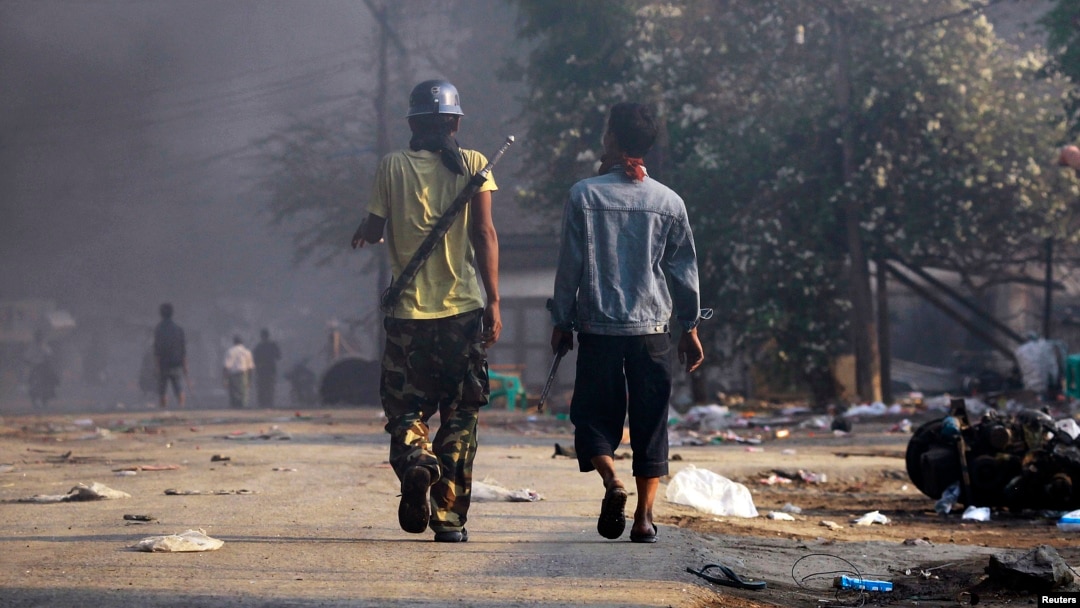 Orang-orang membawa senjata dalam kerusuhan sektarian antara warga Budha dan Muslim di kota Meikhtila, Burma (22/3).